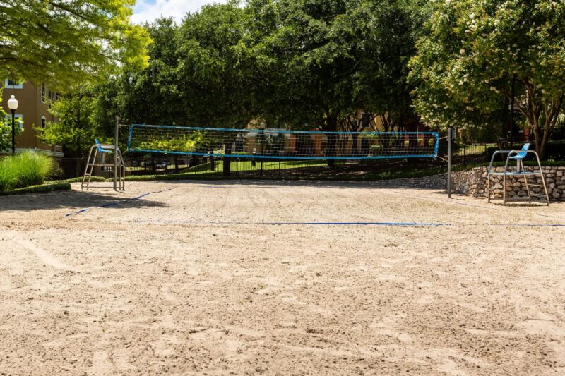 Sandy volleyball court with blue net.